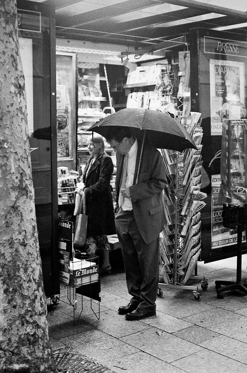 Sous un parapluie à choisir ses journaux