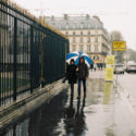 En couple sous un parapluie bleu et blanc